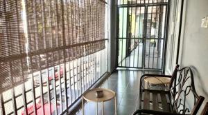 a balcony with two chairs and a table and a window at Ozzy Lodge Semporna in Semporna