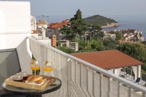 ein Tisch mit einem Teller Essen auf einem Balkon in der Unterkunft Studio Andrea in Dubrovnik