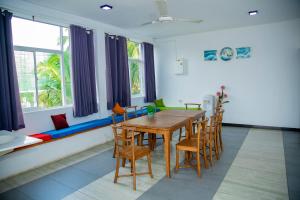 a dining room with a wooden table and chairs at Villa Ocean Dew in Galle
