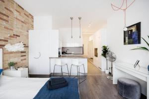a room with a large bed with two chairs and a kitchen at Madach Studio - Heart of Budapest in Budapest