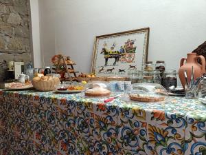 a table with a table cloth with food on it at Albergo diffuso Borgo Gallodoro da Sara in Gallodoro +7 photos