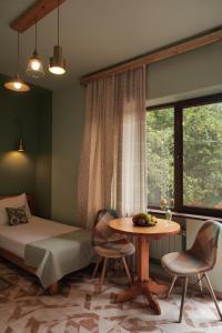 ディリジャンにあるDaravand Guest Houseのベッドとテーブルと椅子のある寝室