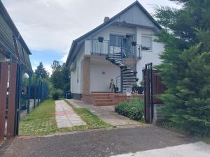 a white house with a spiral staircase on it at Loft Apartman in Zalakaros