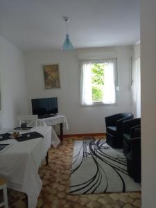 a living room with a table and chairs and a window at villa arc en ciel in Contrexéville
