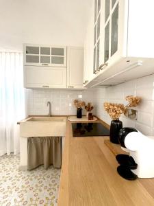 a kitchen with white cabinets and a sink at Masseria San Nicola dei Baroni di Castiglione in Vignacastrisi