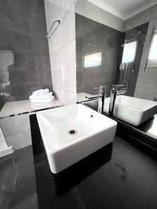 a bathroom with a white sink and a tub at HOTEL BOUTIQUE a ESPLANADA in Castelo Branco