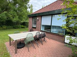 a picnic table and chairs in front of a house at Mekxy in Herkingen