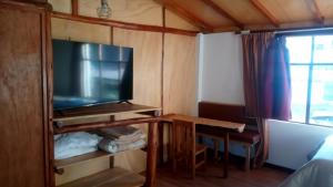 a small room with a television and a table and a window at Inti Panqara in Juliaca