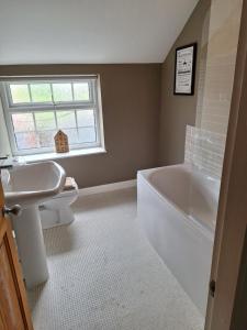 a bathroom with a toilet and a sink and a tub at Fryers Cottage 3 Bedroom Sleeps 6 Cottage in Scarborough +26 photos