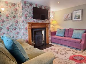 a living room with a fireplace and a tv at Fryers Cottage 3 Bedroom Sleeps 6 Cottage in Scarborough