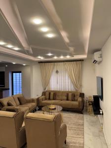 a living room with two couches and a tv at شقة مفروشه فاخرة للايجار الاردن عمان in Amman