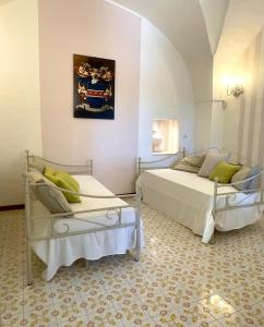 a bedroom with two beds and a couch at Masseria San Nicola dei Baroni di Castiglione in Vignacastrisi