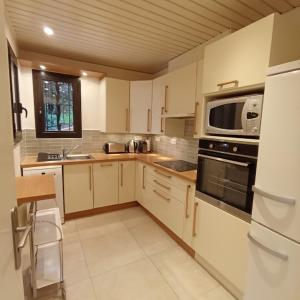 コリウールにある6AMB38 Villa avec terrasse dans résidence avec piscine communeの白いキャビネットと電子レンジを備えたキッチン