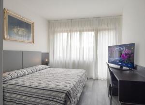 a hotel room with a bed and a flat screen tv at Hotel Cristallo in Conegliano