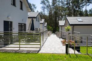 a house with a walkway next to a building at Stylowe Osiedle Wieleń - domy wakacyjne in Wielen Zaobrzanski