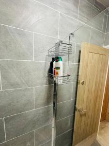 a bathroom with a shower with a shelf on the wall at Burton Urban Apartment A in Burton upon Trent