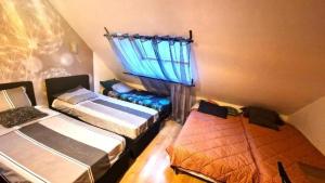 a room with three beds and a window at Suite 2Chambres salle de bain privés toilettes Terrasse Parking 30 min de Paris in Corbeil-Essonnes