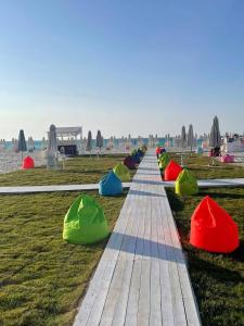 eine Reihe bunter Fässer auf dem Gras in der Unterkunft Santorini Resort apartment in Dawwār Shindī Fannūsh