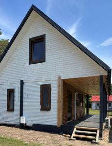 a large white building with a porch at Amber Coast domek nr 4 in Jantar