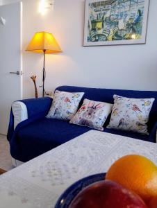 Una sala de estar con un sofá azul y un sofá naranja. en Sandy Bay Apartment in Both Worlds, for over 50s, Gibraltar, en Gibraltar
