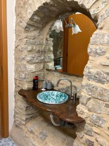 a stone bathroom with a sink in a stone wall at Cortili Himeresi in Termini Imerese