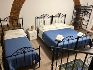 1 Schlafzimmer mit 2 Betten und blauer Bettwäsche in der Unterkunft Cortili Himeresi in Termini Imerese + 10 Fotos
