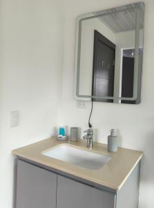 ein Badezimmer mit einem weißen Waschbecken und einem Spiegel in der Unterkunft Apartamento en el centro de Matagalpa in Matagalpa + 3 Fotos
