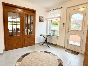 a room with a door and a table and windows at Cosy Holiday Nest in Marienhafe in Marienhafe