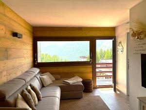 a living room with a couch and a large window at I Dadi Cielo Alto cir VDA Valtournenche 0446 in Breuil-Cervinia