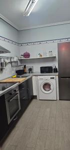 a kitchen with a sink and a washing machine at LIENCRES, céntrico, PLANTA BAJA in Liencres