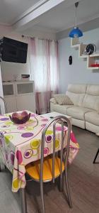 a living room with a table and a couch at LIENCRES, céntrico, PLANTA BAJA in Liencres +2 photos