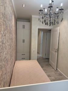 a bedroom with a bed and a chandelier at apartment Tashkent 2 BR centre main St in Tashkent +2 photos