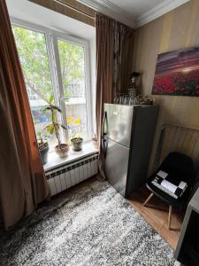 Una cocina con refrigerador de acero inoxidable y ventana. en Palace Hotel, en Chişinău