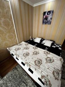 1 dormitorio con cama con edredón en Palace Hotel, en Chişinău