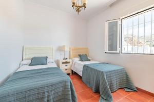two beds in a room with two windows at Villa Girasol in Calahonda