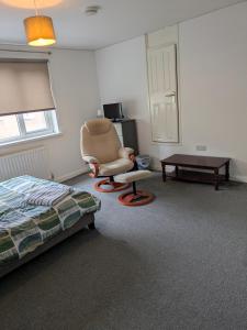 a bedroom with a bed and a chair and a table at Corby Town Vacations Rooms available for Couples & Singles in Rockingham