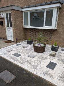 a patio in front of a house with a plant at Corby Town Vacations Rooms available for Couples & Singles in Rockingham