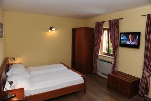 een slaapkamer met een bed en een tv aan de muur bij Guest House Stancija Kovacici in Opatija +105 foto's