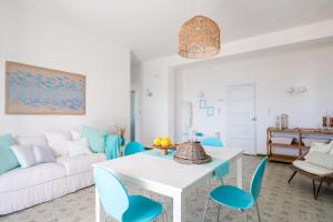 a living room with a white couch and blue chairs at Natoli Beach House & Villas Villa Manfredi in Molino San Biagio +14 photos