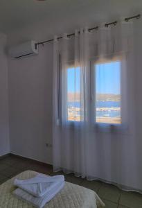 a bedroom with a bed and a window with a view at Drymonas Sunset in Drymonas