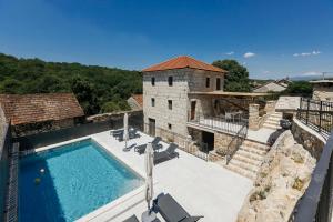 a house with a swimming pool next to a building at Villa Mila Imotski Makarska in Zmijavci
