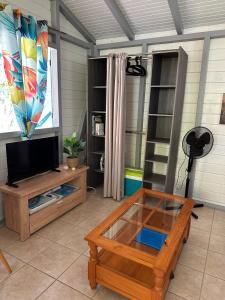 a living room with a tv and a coffee table at Le ptit paradis créole in Sainte-Rose