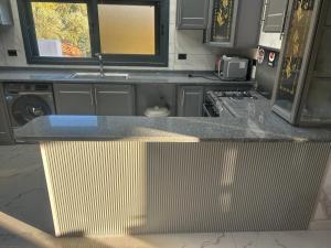 a kitchen with a counter top with a sink at مزرعة وفيلا غابة الارز in Jerash