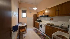 a kitchen with wooden cabinets and a stove top oven at Casa Aranci in Cattolica Eraclea