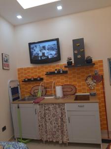 a kitchen with a sink and a tv on the wall at Dimora Stabiae in Castellammare di Stabia