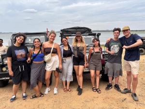 un gruppo di persone che si trovano di fronte a un veicolo di Sigiriya Lions Rest Hostel a Sigiriya