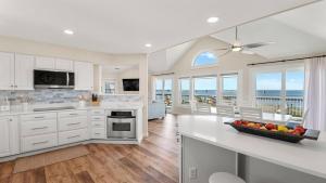 une cuisine avec des armoires blanches et une vue sur l'océan dans l'établissement Luxury Waterfront Villa, à Rodanthe 9 autres photos