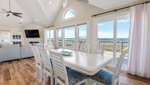 - une salle à manger avec une table et une vue sur l'océan dans l'établissement Luxury Waterfront Villa, à Rodanthe