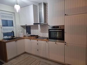 a kitchen with white cabinets and a stove top oven at Zakątek Rumiankowa Rewal in Rewal