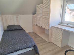 a small bedroom with a bed and a window at Zakątek Rumiankowa Rewal in Rewal
